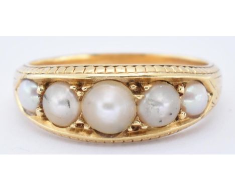 An antique 18ct gold and half pearl ring. The ring set with 5 cultured graduating pearls within chase decorated setting to a 