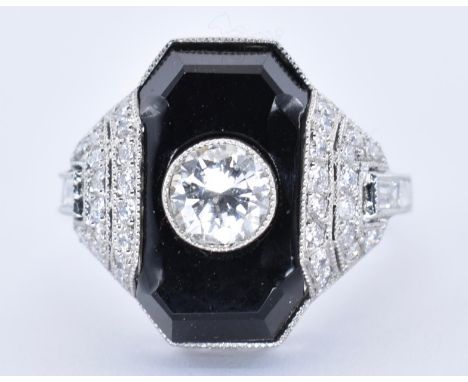 A platinum onyx and diamond Art Deco dress ring. The ring set with a round brilliant cut diamond within an onyx plaque having