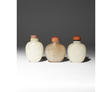 THREE CHINESE SNUFF BOTTLES 19TH CENTURY One carved in pale celadon jade with stylised flowerheads set amidst fronds and scro