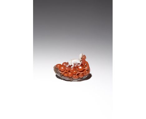 A CHINESE AGATE CARVING OF A SQUIRREL AND GRAPES QING DYNASTY Formed as a bunch of grapes carved in a red section of the ston