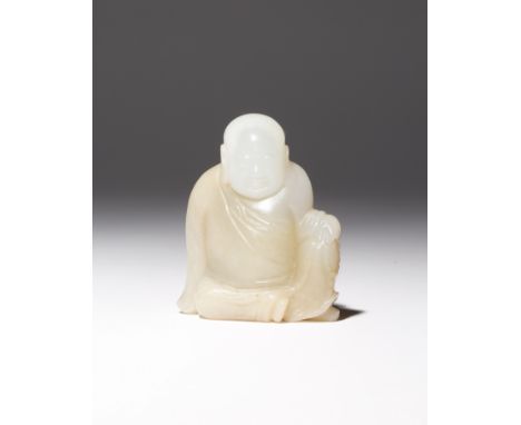 A CHINESE WHITE JADE CARVING OF A LUOHAN QING DYNASTY Depicted seated dressed in monk's robes, his garments picked out in a d