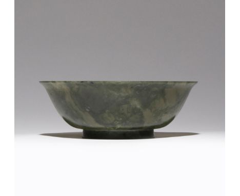 A CHINESE SPINACH-GREEN JADE BOWL 18TH/19TH CENTURY The plain body carved with a gently flaring rim, all raised on a short sp