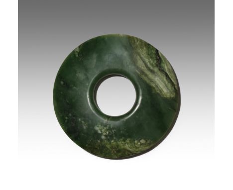 A CHINESE ARCHAISTIC SPINACH-GREEN JADE BI PROBABLY LATE QING DYNASTY The disc tapering at the edges, with a circular apertur