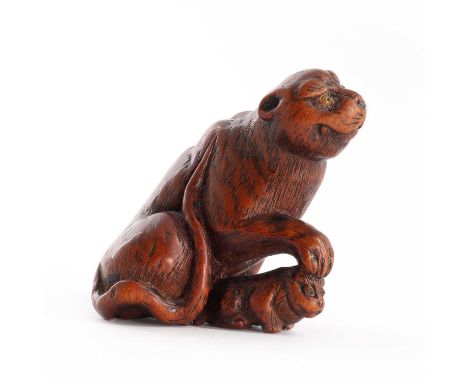A Japanese boxwood netsuke,Edo period, 19th century, in the form of a tiger seated with a paw on the head of her cub, with tr