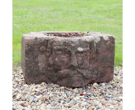 A sandstone planter,the front carved as a bearded 'green' man, 61cm wide31cm highCondition ReportWeathered, worn and characte