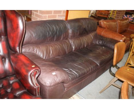 A LARGE BLACK LEATHER THREE SEATER SOFA