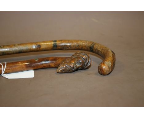 A FOLK ART WALKING STICK WITH PAINTED FIGURAL AND LANDSCAPE DECORATION, together with a walking cane with the pommel carved i