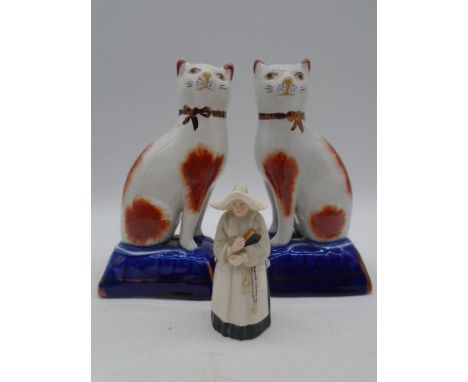 A pair of 19th century Staffordshire cats, height 18cm along with a Royal Worcester candle snuffer in the form of a nun (smal