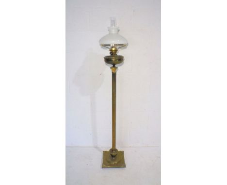 A turn of the century brass floorstanding oil lamp on Corinthian column base, with glass shades.