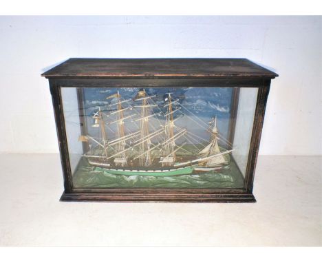 A cased turn of the century hand-built model of a four masted ship "Maggie", with a smaller yacht and light house in a natura