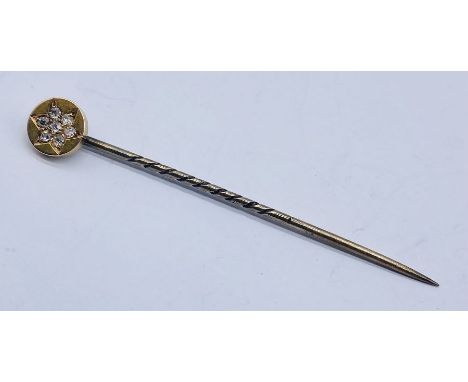 An unmarked rose gold tie pin/stick pin set with 7 diamonds