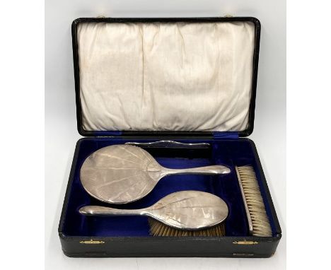 A cased hallmarked silver (Birmingham 1921) Art Deco dressing table set consisting of mirror, two brushes and a comb