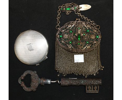 A hallmarked silver circular compact, engine turned; a gilt metal filigree evening purse, jewelled, with mirror to lid; a nov