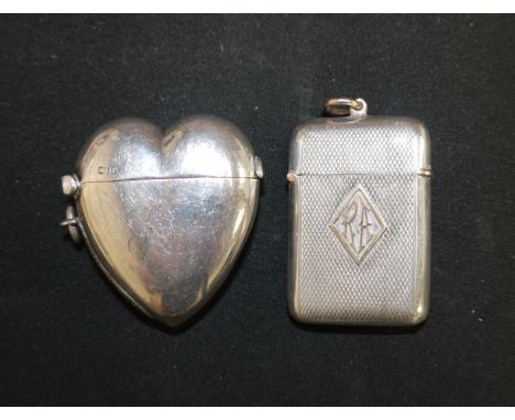 An engine turned silver Vesta case with raised yellow metal loop and monogram 'RA', London 1911; a silver heart shaped Vesta 
