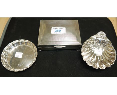 A silver engine turned cigarette box, Birmingham 1961 (dented); a shell dish, Birmingham 1950; a ribbed circular dish, Sheffi