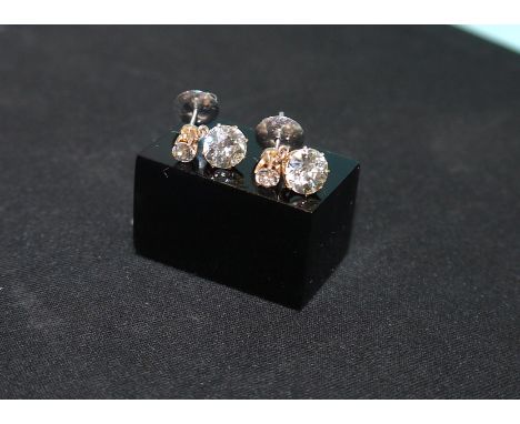 A pair of diamond drop earrings in 18 carat hallmarked white and rose gold settings, the top two old cut diamonds .16 carats 