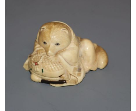 A Japanese Meiji period carved ivory netsuke of a fox cub on a cushion, with inset eyes 3.5cm high