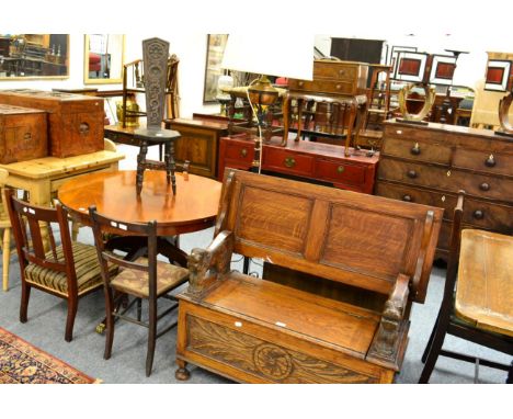 An carved oak monks bench with hinged top and seat together with a spinning chair, standard lamp, a pair of low chairs and on