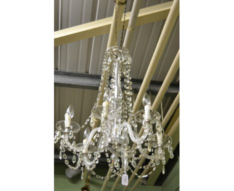 A gilt metal scroll arm eight light chandelier and a smaller glass example  