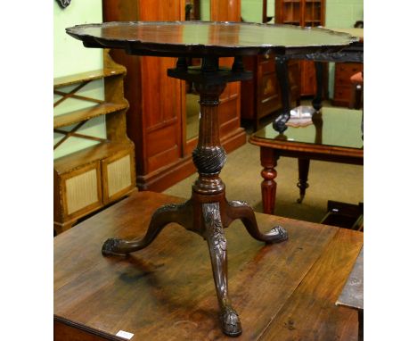 A mahogany tilt top tripod table with shaped rim, bird cage and carved cabriole supports 