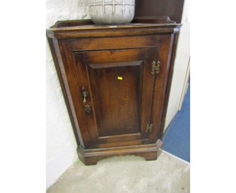 GEORGIAN DESIGN OAK CORNER CUPBOARD, panelled door with shaped brass hinges and escutcheons and shaped shelf interior, 29" he