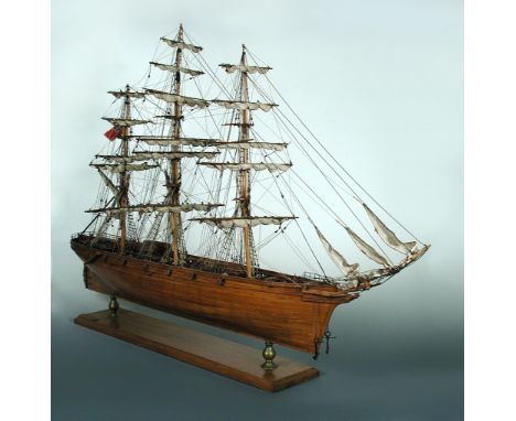 A wooden scale model of 'Cutty Sark' by Ceuneau Marine of Mauritius, the three masted ship with sails furled and with the Red