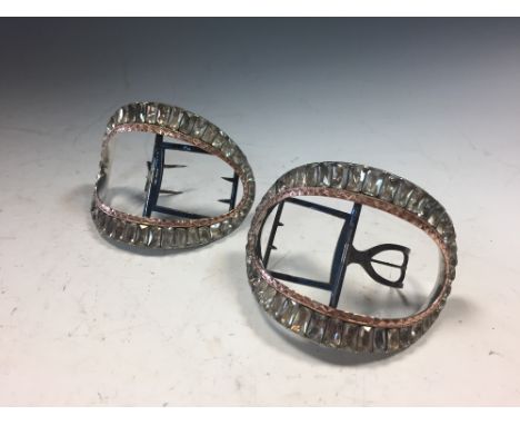 A cased pair of Georgian gilt metal shoe buckles and another pair in paste, the first arched rectangular with bands of flower