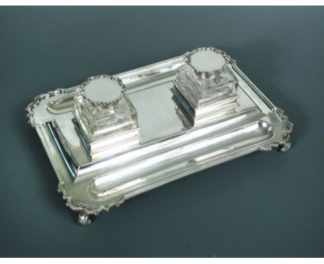 A George V silver desk inkstand by the Goldsmiths' and Silversmiths' Company, London 1919, shaped rectangular base the corner