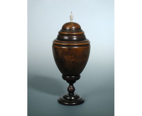 A late 18th century coconut cup and cover, the latter with bone urn finial to its domed top, the ovoid body on a wood bun sha