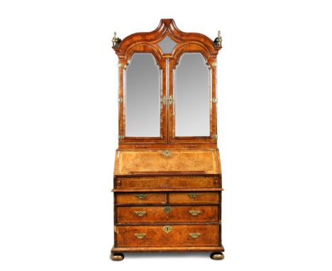 A William and Mary walnut bureau bookcase, the double dome ogee arch moulded top above a pair of mirrored doors with candle s