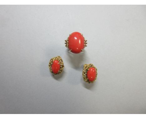 A red coral ring and matched pair of screw-back earrings, the ring with a 18mm x 14mm oval cabochon red coral four claw set a