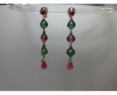 A pair of ruby, emerald and diamond ear pendants, each post headed by an oval cut ruby in a border of diamond chips on an oxi