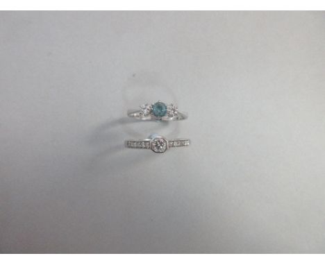 A contemporary diamond ring and a diamond and aquamarine three stone ring both set in 18ct white gold, the first with a round