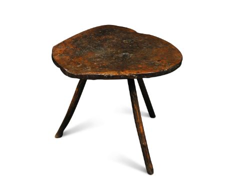 An 18th century rustic elm stool, the patinated misshapen log top, on three stick legs 50 x 55cm (20 x 21in)  The top has bee