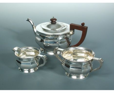 A silver three piece tea set, by Deakin & Francis, Birmingham 1926, of circular form decorated with eight pressed panels givi