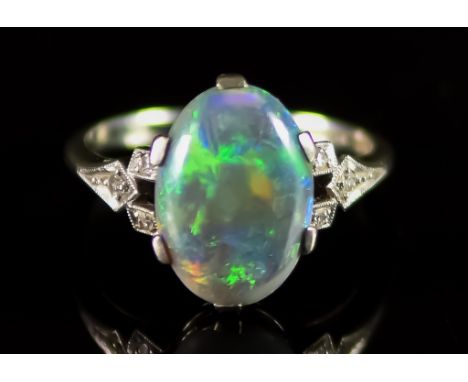 An 18ct White Gold and Platinum Opal Cabochon Ring, 20th Century, set with a centre opal stone, 13mm x 8mm, flanked by small 