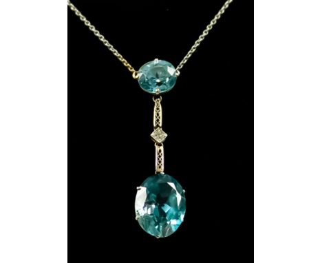 A 9ct White Gold Blue Topaz Drop Pendant, 20th Century, set with two blue topaz stones interspaced by one small diamond, susp