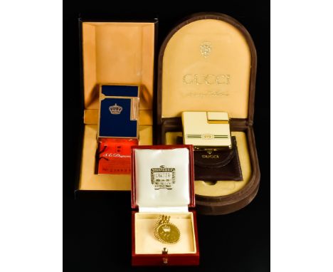 A Monogrammed Brooch and Two Cigarette Lighters, 20th Century, comprising - a yellow metal brooch by Cartier, bearing the mon