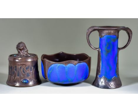 Three Pieces of Bretby Pottery, comprising - a bronzed finish tobacco jar and cover of Art Nouveau design, the cover with lad