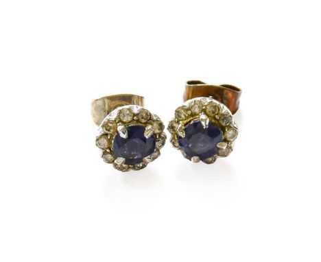 A Pair of Sapphire and Diamond Cluster Earrings, the round cut sapphire within a border of round brilliant cut diamonds, in w