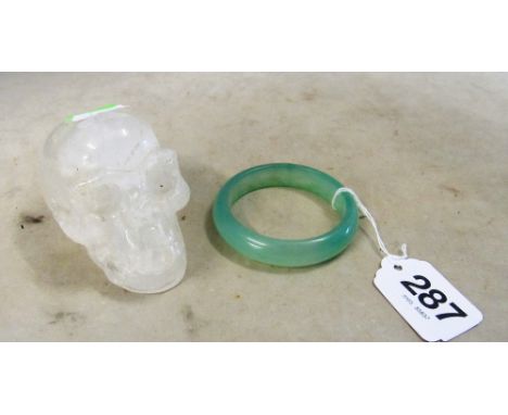 A crystal skull paperweight and green bangle