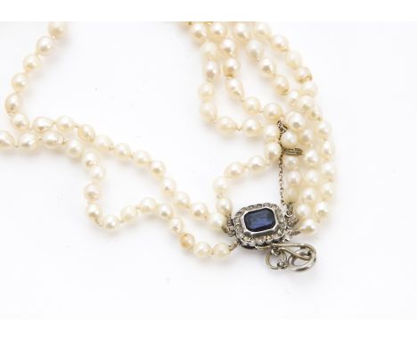 A vintage three strand pearl necklace, the graduating white pearls on varying lengths of twist knotted cotton, having a paste