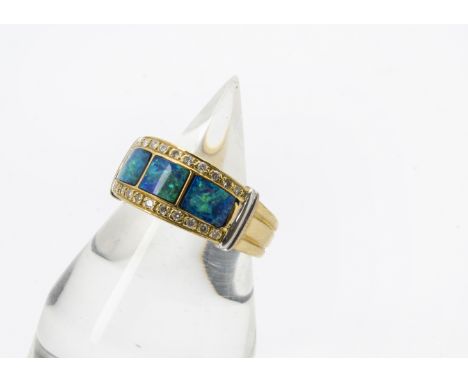 A modern 18ct gold opal and diamond dress ring, thick ribbed band having tablet set with three panels of black opal with a ro