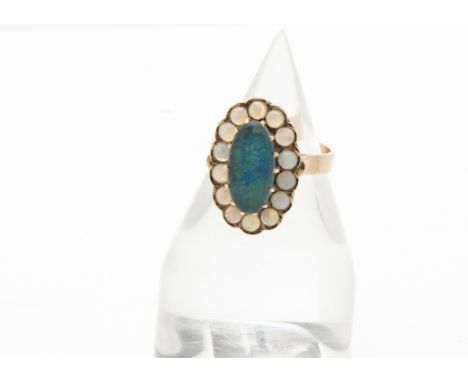 A 1970s Middle Eastern gold and opal cocktail dress ring, the central dark doublet opal with white opal surround, 4.5g and si