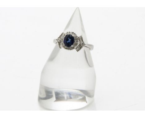A modern 18ct white gold diamond and sapphire ring, the shoulders set with baguette cuts and a brilliant cut, and the blue sa