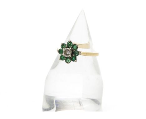 A vintage emerald and diamond flower head cluster ring, centred with a brilliant cut within eight green stone surround, marke