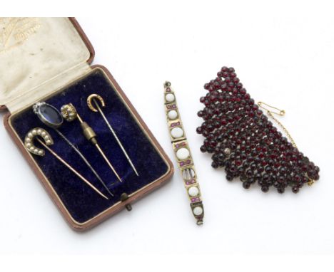 Four Victorian and later stick pins, including a gold seed pearl and diamond stock pin, two horseshoe shaped and a paste set 