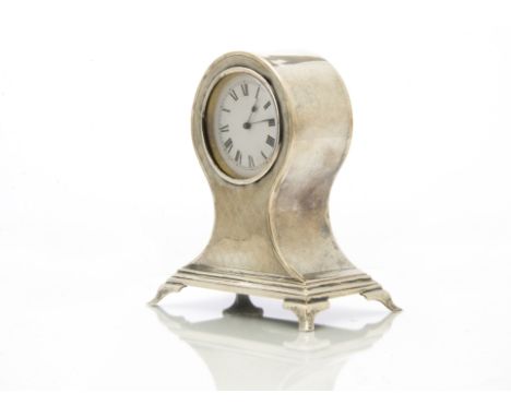 An early George V period silver mantle clock by William Comyns, rectangular spreading base with four supports and waisted upp