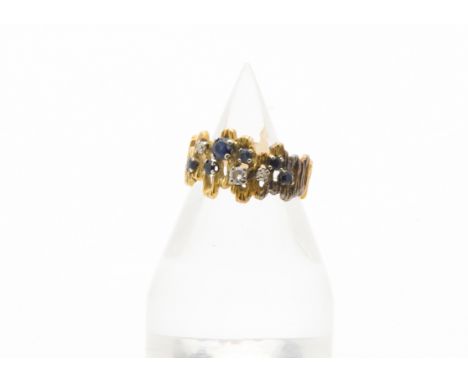 A 1970s 18ct gold sapphire and diamond cocktail dress ring, the abstract textured band set with six round cut blue sapphires 