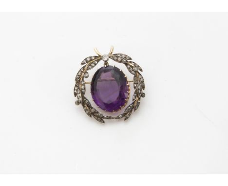 An Edwardian amethyst and diamond brooch, the two rose cut set laurels in silver and gold supporting a drop pendant of a larg
